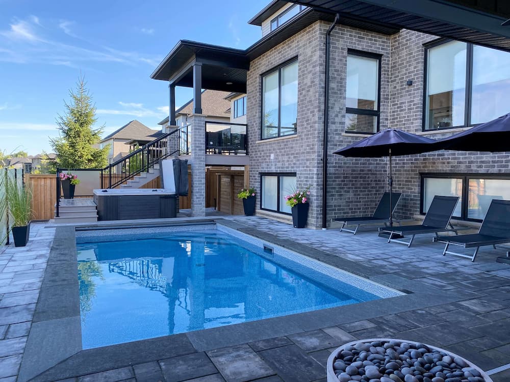 Concrete inground pool installation with customized hardscaping.